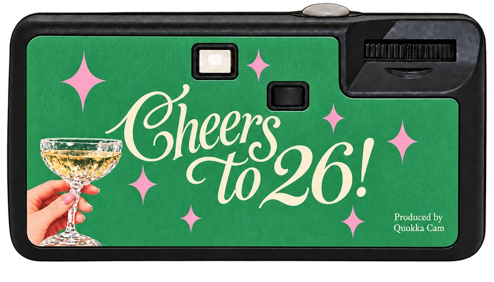 Back of the same disposable camera: a raised champagne coupe and the line Cheers to 26!