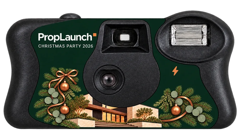 An Out of Office Pack camera: a dark green PropLaunch Christmas Party 2026 sticker with copper baubles and a modern house