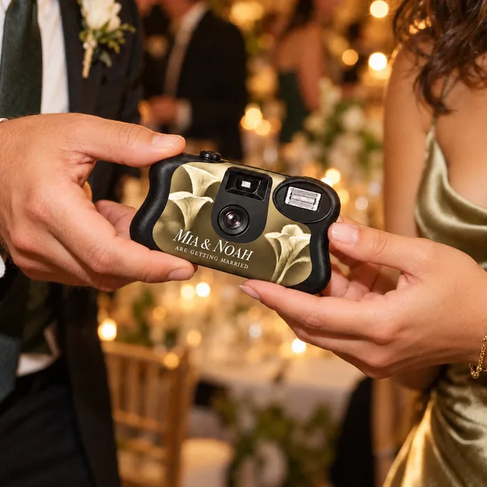 One guest passing the camera to another across a candlelit reception